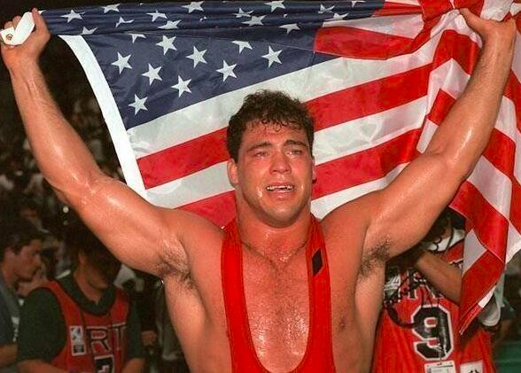 HistoryInPics's tweet photo. Wrestler Kurt Angle holds up the American Flag after winning gold in the 1996 Olympics with a broken neck. https://t.co/nLVelBZirK