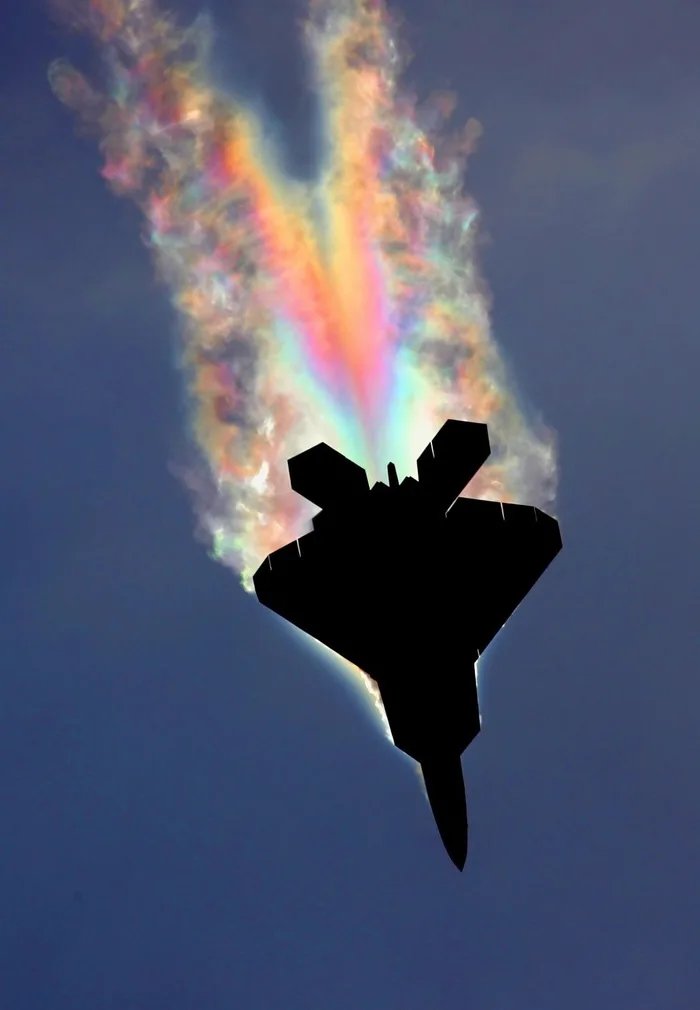 encrypt256's tweet image. An F-22 Raptor's air condensing over the fuselage due to low pressure. Sunlight hitting at just the right angle to cause a psychedelic effect.
