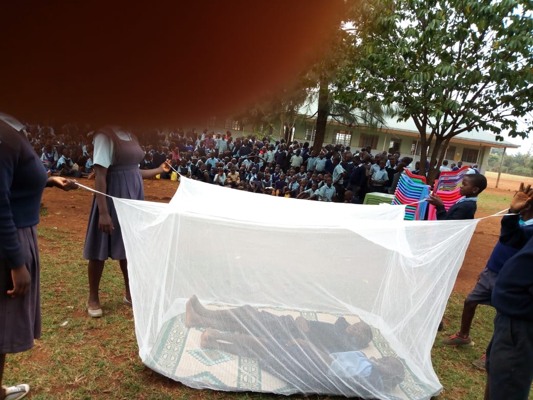 cinco_ngo's tweet photo. Ratta health club demonstrating proper net use during closing day ceremony.Ensure your children are sleeping under a treated mosquito net during this August holiday. Eradicating this disease begins with you as a parent ensuring your kids are sleeping under a treated mosquito net. https://t.co/vrxpSPlvtw