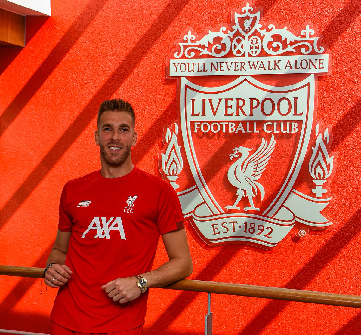 Adrián posa con el escudo del Liverpool.