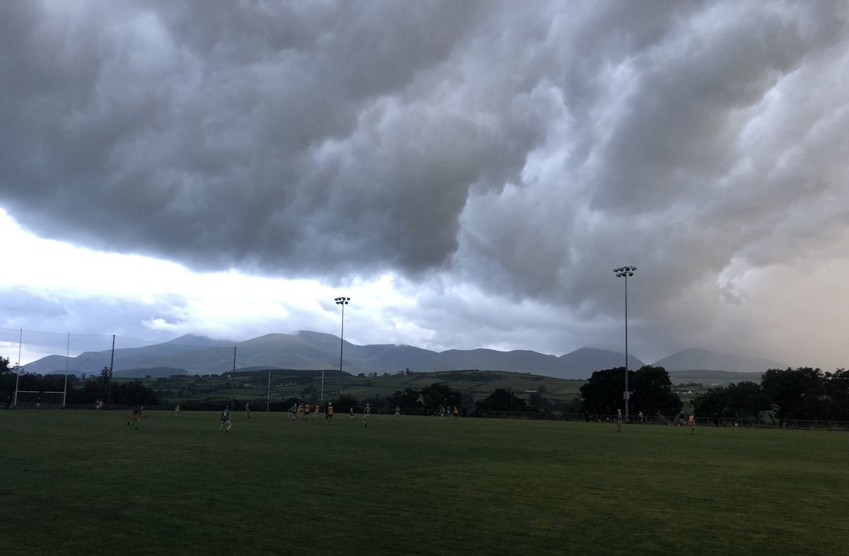 JohnBrollyJB's tweet photo. Hurling underneath storm ⛈ clouds with the Mourne mountains 🏔 in the background 🔴⚫️ @OfficialDownGAA https://t.co/g53eMpxzFq