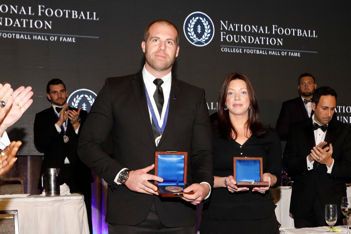 NFFNetwork's tweet photo. School shooting heroes Jason Seaman &amp; the late Aaron Feis (represented by wife Melissa) were co-recipients of the NFF’s 2018 Gold Medal. The NFF honored the courage &amp; selflessness shown by the two youth football coaches with their students’ lives on the line. #NFFHistory #CFB150 https://t.co/ksU5SVIYEZ