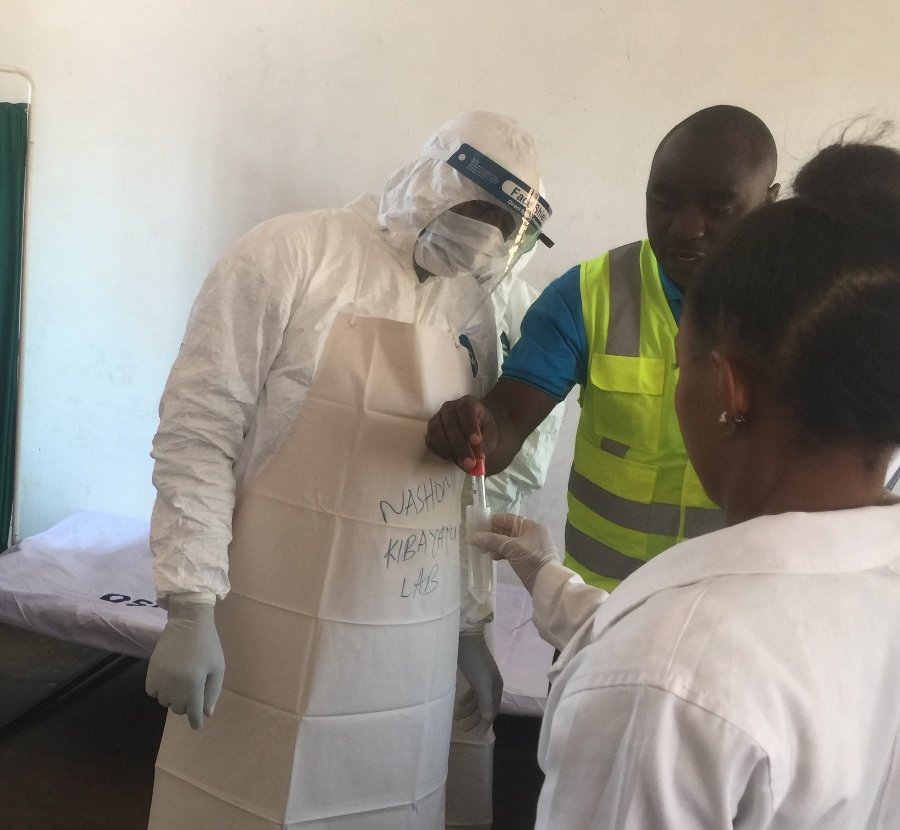 Hakingowi's tweet photo. Mwezeshaji wa zoezi la kupima Utayari wa kukabili Ugonjwa  wa Ebola mkoani Kigoma, kutoka Wizara ya Afya,Dkt.Faraja Msemwa akifafanua umuhimu wa vifaa Kinga, kwa watoa huduma ya Afya katika Kituo cha Afya Ilagala wakati wa kuigiza zoezi la hilo  lililofanyika  katika kituo hicho https://t.co/kJ1uN3xCp8