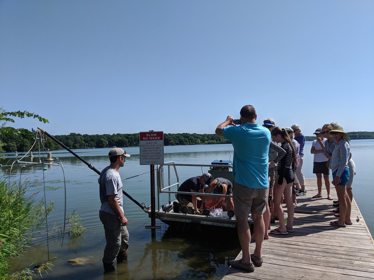 Group of people on dock watching demonstration on boat
