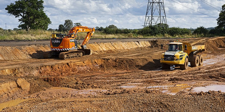 Excavator and a tipper working on a muddy construction site. 