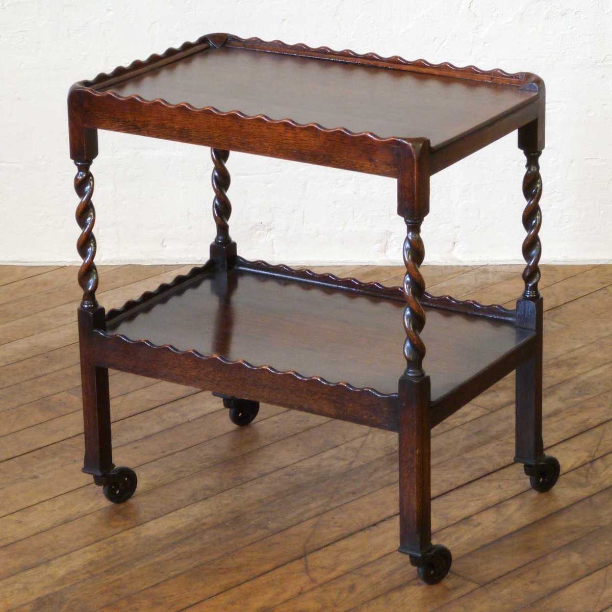 witchantiques's tweet photo. An attractive oak tea trolley from the 1920s. Unusual to have a wavy edge to both tiers, plus the twists to the legs. The whole piece is in excellent original condition, including the castors. https://t.co/MknKvLQmKT
