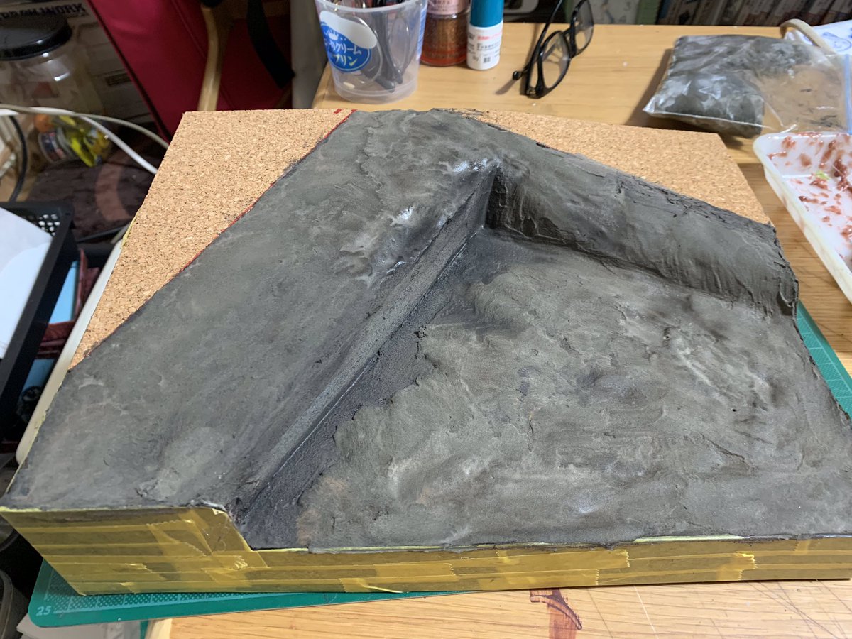 犬男爵 プラ板で枠作りサフがけ ペーパーをかけた後に黒色塗装 マスキングしスタイロフォームのベースを入れて接着 道路部分にコルクシートを貼り地面はダイソーのカラー軽量粘土の黒に茶を足した物を付ける 水で表面をならすと写真3の様ないろになり