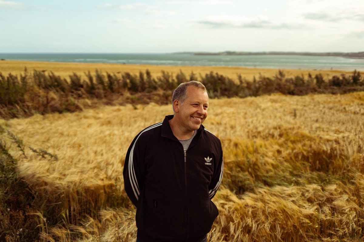 WaterfordWhisky's tweet photo. Ed Harpur, Bannow Island. Tones of gold, blue &amp; grey. Rain, sun, wind &amp; then flat calm all within a few hours; the barley’s at the mercy of the elements here. Ed’s very hopeful for this 2019 crop... https://t.co/94vTYpld3z