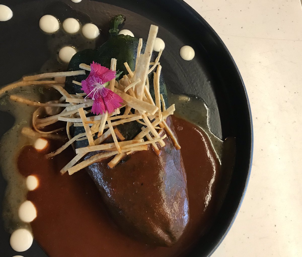 El segundo chile se llama “el chile de allá”, es una reinterpretación del clásico #chileennogada, pero este está relleno de cecina con ajo, cebolla y queso. ¿Qué le parece? Esto lo pueden probar en <a href="/FoodTCMX/">Food Trade Center</a> 👌🏻😋.