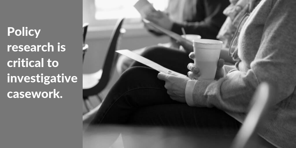 holding paper and Styrofoam cup of coffee