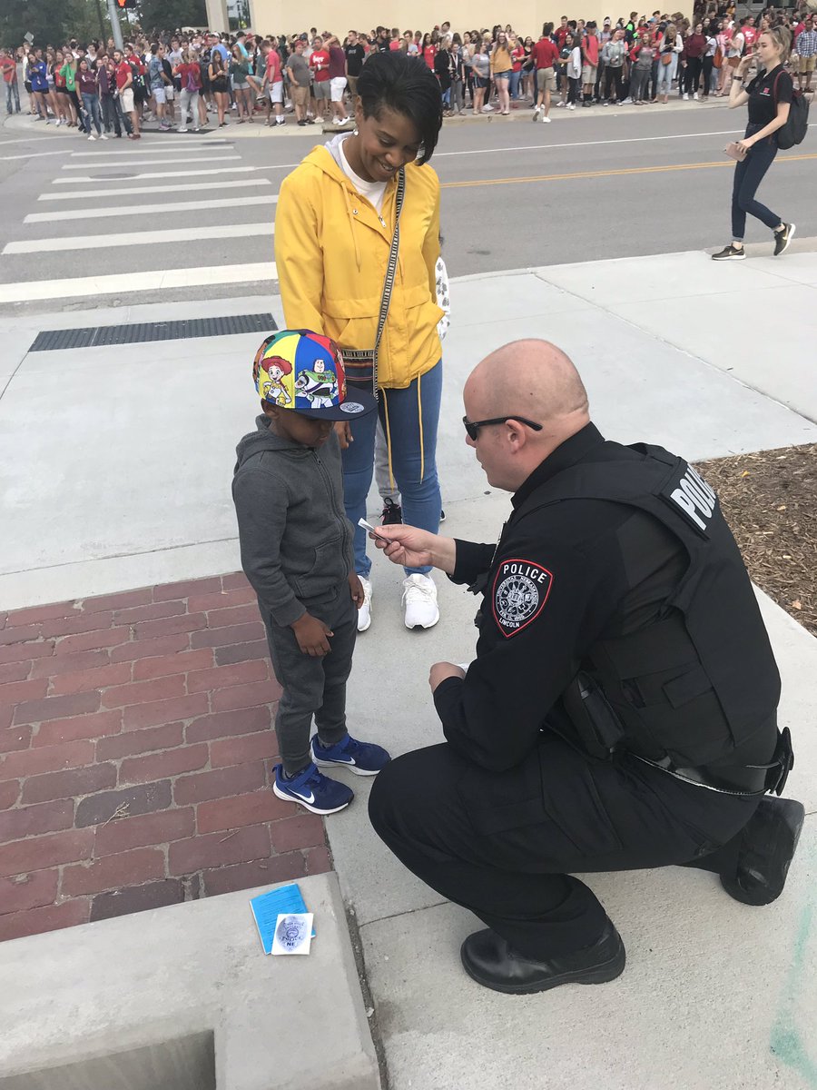 UNLPD's tweet photo. Ofc. Rubottom handing out a sticker to a future police officer #bigredwelcome #UNL https://t.co/FbBFh9gLFI