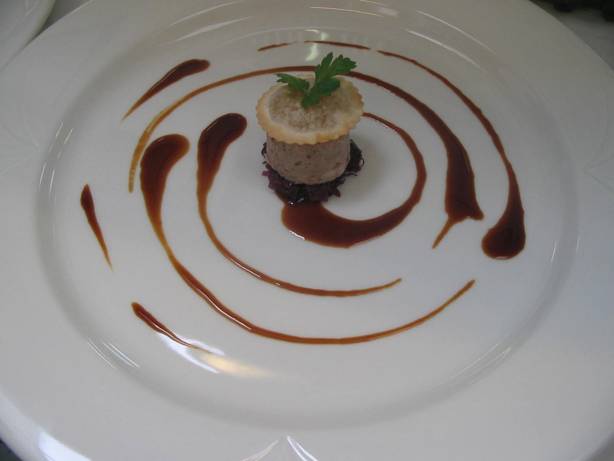 Testina di maialino agli agrumi con cavolo rosso stufato e raviolo di mele.