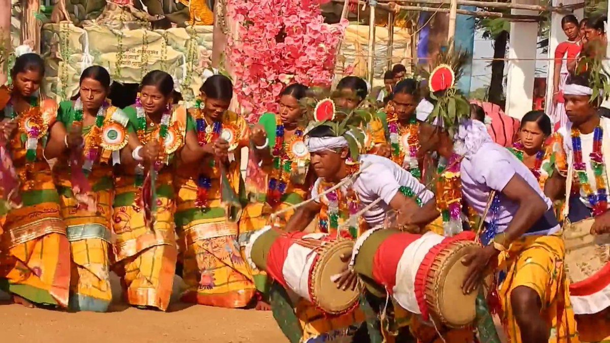 TUMDAK (MADAL)drum made of wood or burnt clay shells & animal skin. always made in pairs, tuned together in same pitch. left side produces a deeper sound than right one. worn around shoulders with a Kandhach (leather strap) played accompanying Santhal Dance.