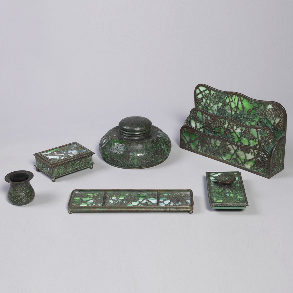 smithsonian's tweet photo. We have office supply envy for this Tiffany Studios desk set, ca. 1910 to 1920, in our @cooperhewitt. Tiffany produced objects that combined decorative appeal and utility, and the Grapevine pattern became one of their most recognizable motifs. https://t.co/kCxSe13sh2 https://t.co/EahiHGh7Wc