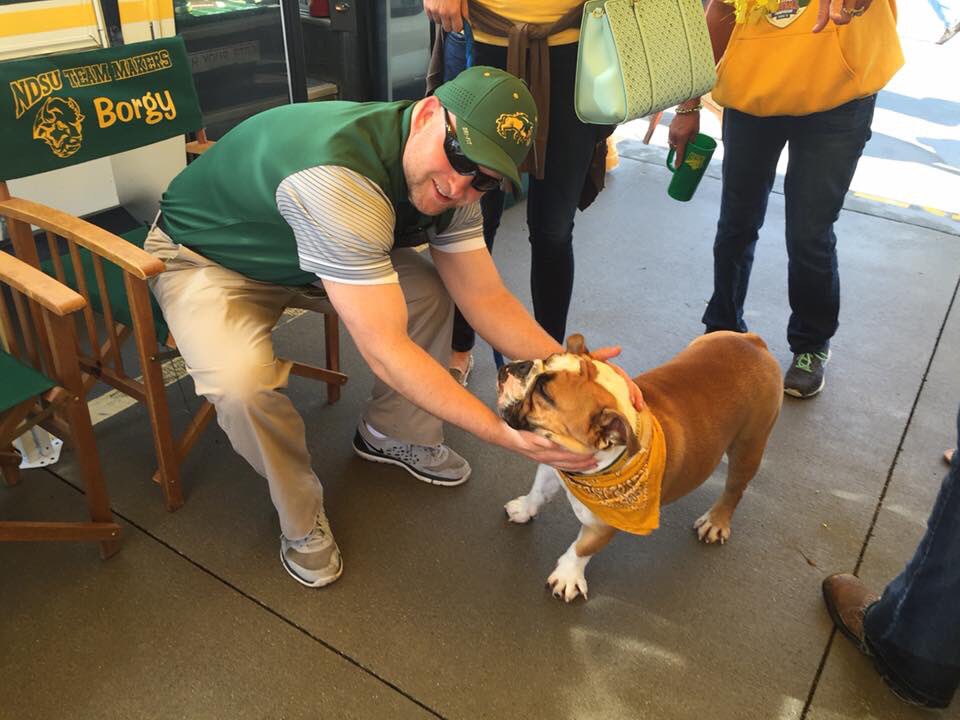 SwanyND's tweet photo. @ndsubookstore My pal Hounds is rocking some Bison gear in the tailgate lots in this pic! But youβre spot on, I need to gear up the little pups with some #BisonSwag! π€πΌπΆ https://t.co/pzC6lNmqGz