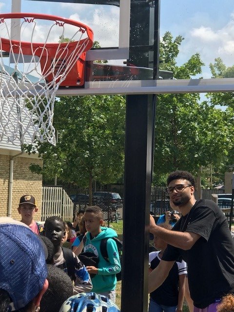 RegionWaterloo's tweet photo. NBA star and Kitchener native Jamal Murray @BeMore27 returned to Amos Avenue in Waterloo to dedicate a new community basketball court. Here he is raising the net for the first time. https://t.co/AA68az5E9h