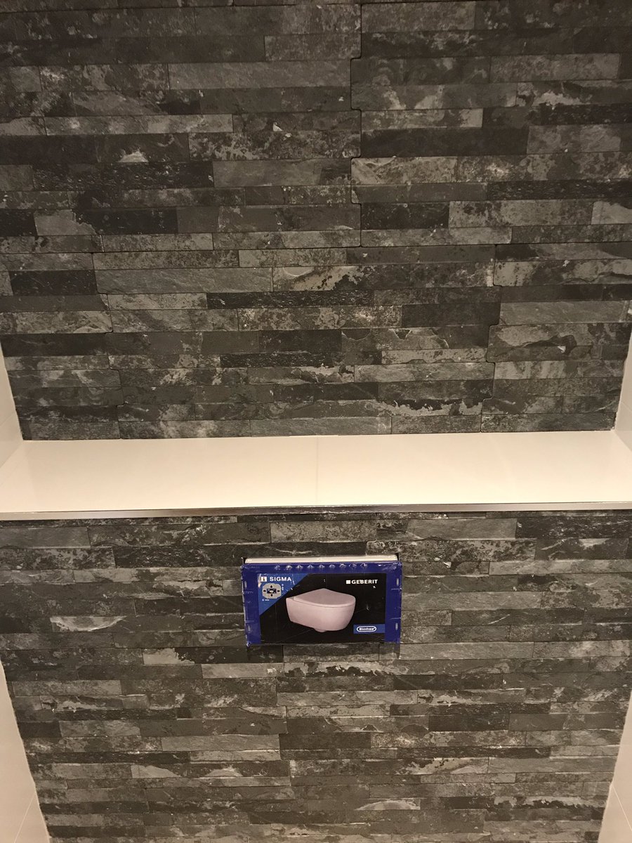 Finished of this toilet gloss white porcelain and splitface effect porcelain tiles as a feature wall