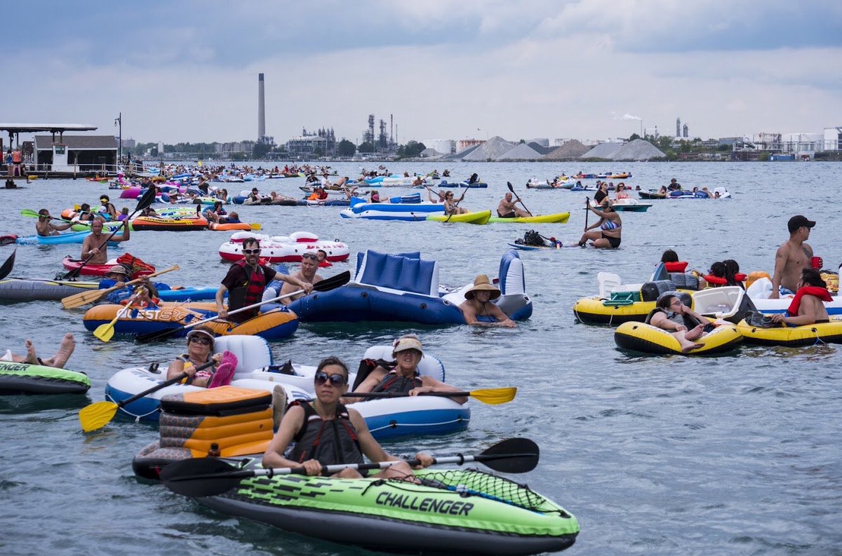 bmwellsphoto's tweet image. I’m ending my #FloatDown tweets with just a few more frames, including one of @PortHuronFire Firefighter Steve Didocha helping to tow a group of floaters on what appears to be a floating picnic table with a Tiki-style roof towards the U.S. shoreline (fourth photo).