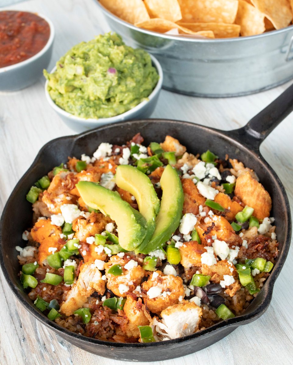Your favorite skillet, now better than ever... The Cowboy Skillet with rice, fried chicken tenders, queso blanco, bacon, avocado, fresh jalapeños, cilantro, hot sauce, blue cheese crumbles.