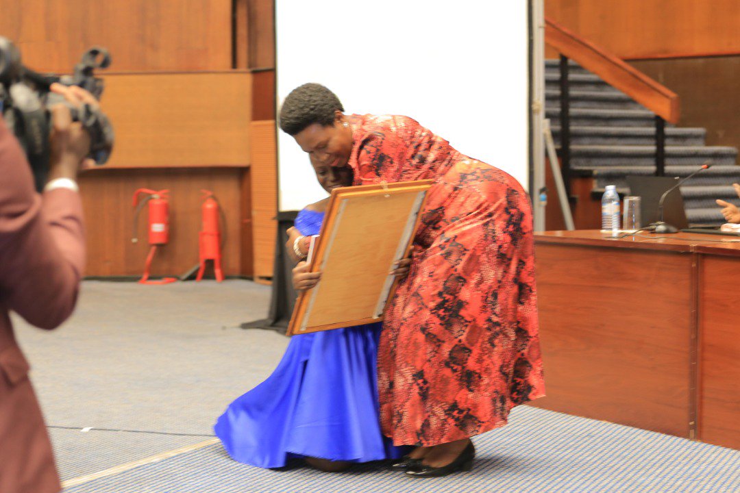 duchess_flowers's tweet photo. Amazing Grace Kirabo gives minister Rosemary Sseninde an art piece made by herself depicting a chapter in her book (Nurtured by a Blind mother) and a copy of the book itself. #PALFA2019Kampala https://t.co/6Cunka7pLY