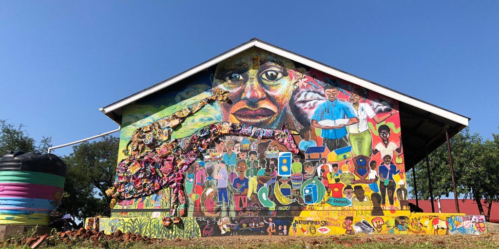 ArtolutionOrg's tweet photo. The latest mural from Bidi Bidi refugee settlement in northern Uganda emphasizes the importance of gender equity in education to the lives, the families, the community, and the environment - symbolized by the cherished, giraffes, a new #Artolution #foundstrument #soundstrument. https://t.co/Hm5OZUL3Ql