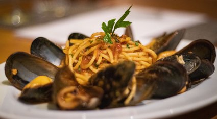 Our Gli Spaghetti alle Cozze – Spaghetti with fresh mussels and tomato will transport you to the Italian coast in just one bite! Book your table now.