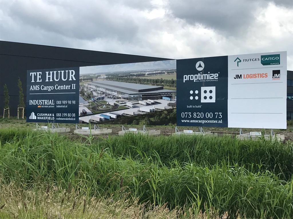 Signmatch's tweet photo. Op Schiphol Logistics Park verrijst AMS Cargo Center II. Om de omgeving te informeren over de bouwwerkzaamheden, plaatsten wij een #projectbord van 20 x 4 meter en een van 10 x 4 meter. op onze medium constructies beton en staal. #duurzaam https://t.co/otbJQkXtuB https://t.co/v1jT58NvrG