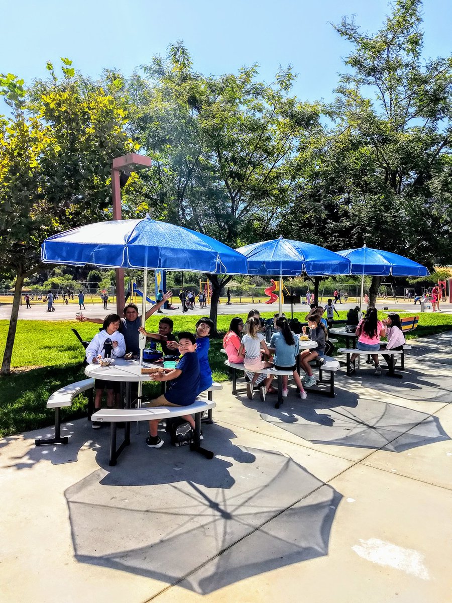 MMMustangs's tweet photo. Students @MMMustangs are already enjoying the new tables with umbrellas with their recess friends! #outdoorclassroom #innovativelearningspace #wave @VistaUnifiedSD @VistaBlueprint https://t.co/55LVGNxIGL