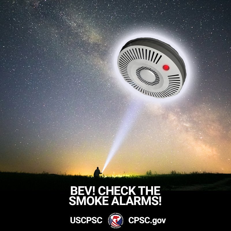 A giant smoke alarm flying in the sky. A person with a flashlight looking up at it, shouts, "Bev! Check the smoke alarms!