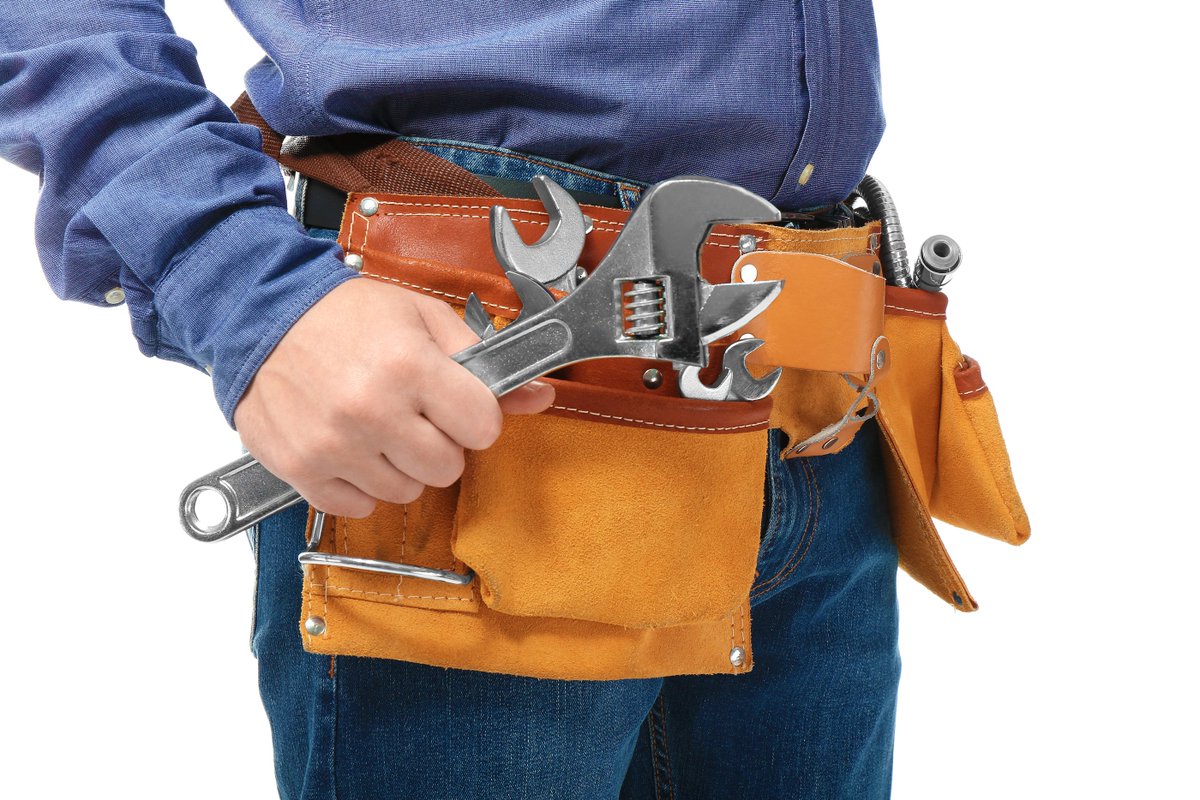 Full Length Portrait Of Mature Technician Wearing Hardhat While Carrying Tool Bag Against White Background Stock Photo