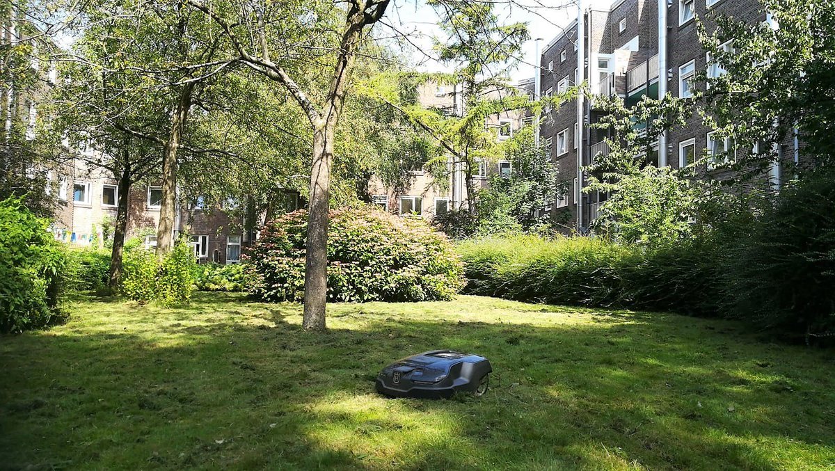 HOEK_groen's tweet photo. Vandaag is er een maairobot geïnstalleerd in twee tuinen van Woonstichting De Key in hartje Amsterdam. Dit leverde direct enthousiaste reacties op van bewoners. Deze duurzame oplossing is stil en zorgt voor een strak gemaaide grasmat. Optimale groenbeleving! #maairobot #duurzaam https://t.co/OlDyA1aBKG