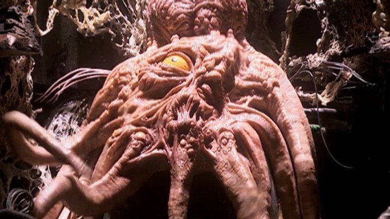 A Dalek mutant or Kaled mutant, a pinkish tentacled squid-like creature with a single eye and a protruding brain.