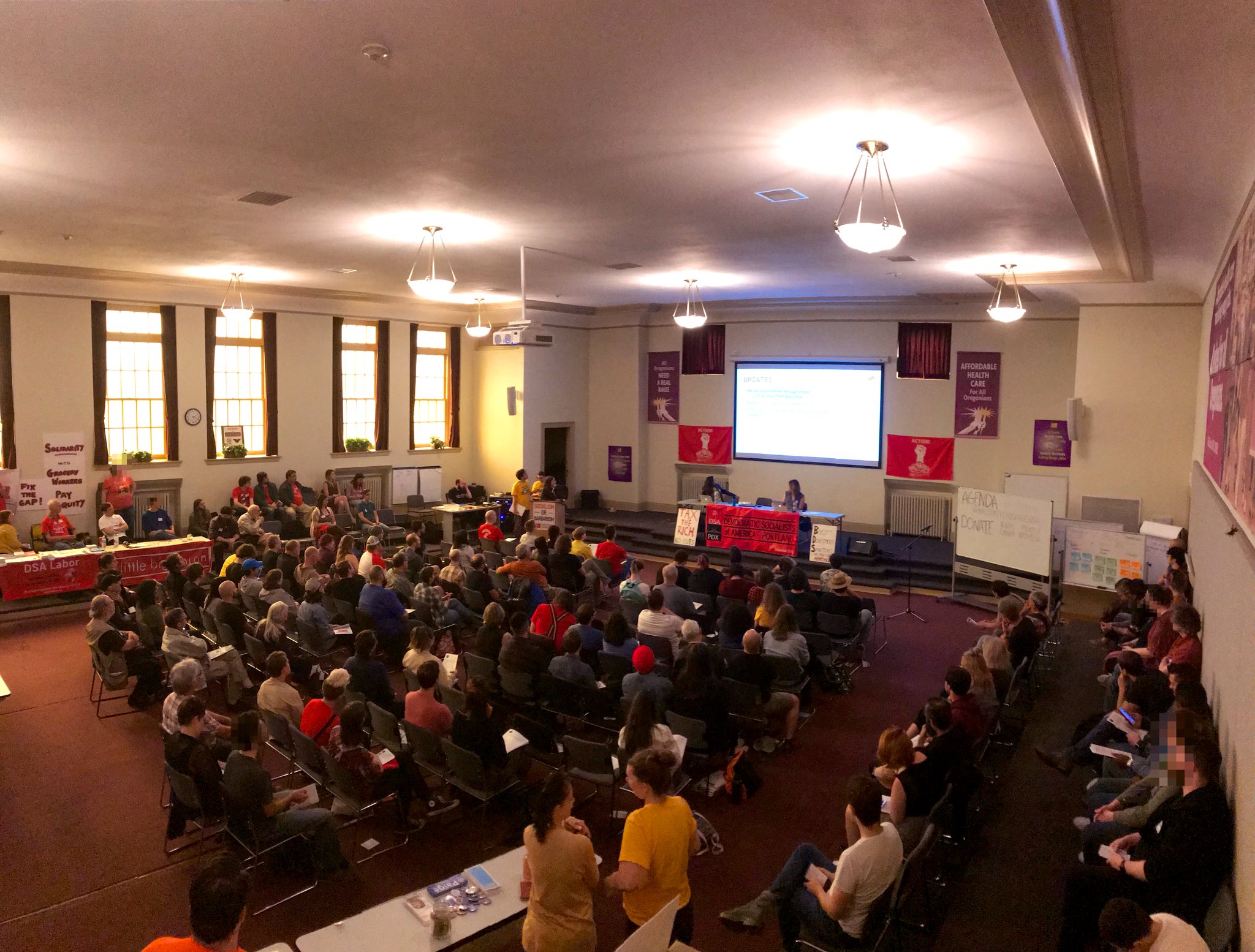 Photo of the September general meeting. 130 socialists in the room. DSA Banners strewn about.