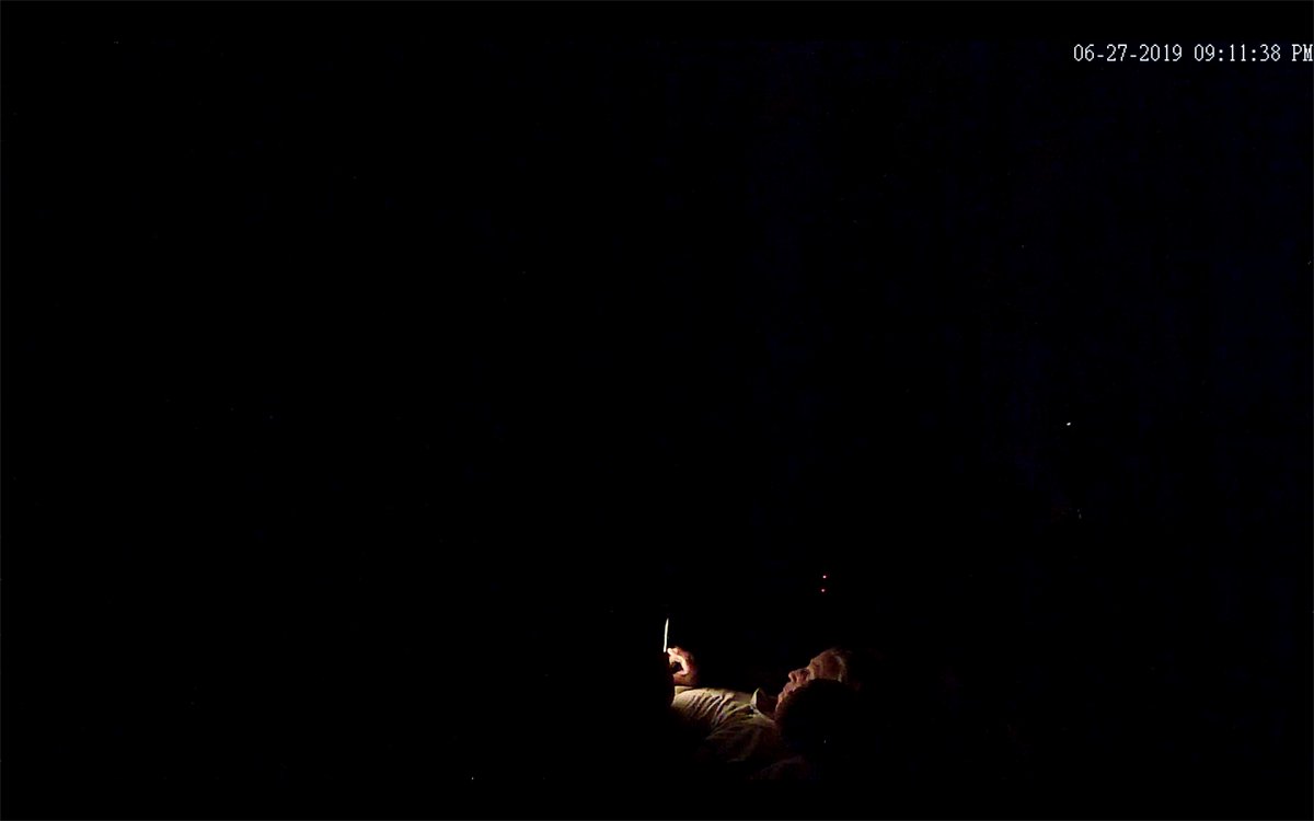 elderly women on her phone in bed surrounded by darkness