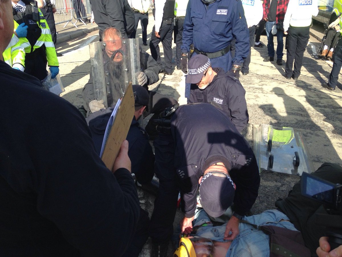 CAATuk's tweet photo. Sit in the road as police cutting team tries to remove a lock-on blocking the road to the DSEI arms fair #StopDSEI #freemovementforpeoplenotarms https://t.co/lCb2pjzC6m