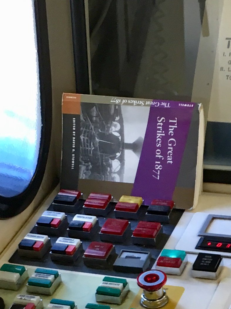 Book: "the great strikes of 1877", placed on top of the airport gate controls.