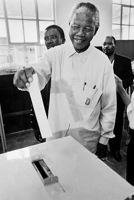 es elegido presidente de Sudáfrica (1994) en una fanfarria de adulación de medios de todo el mundo, ya que los medios de propiedad judía elogian el día histórico en que un hombre negro es elegido para gobernar Sudáfrica.