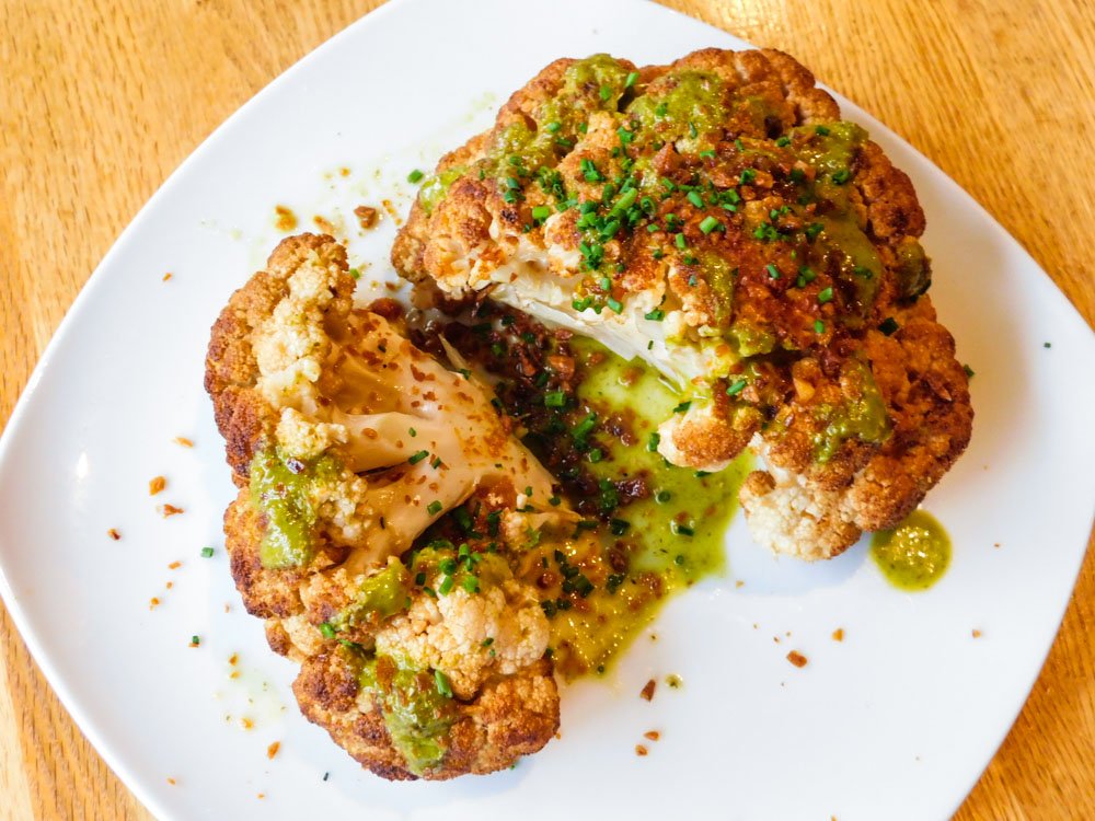 Yep, we like to have fun with our veggies! Loaded up with crispy garlic and citrus-cumin vinaigrette, this whole roasted cauliflower is a must with any of our mains.