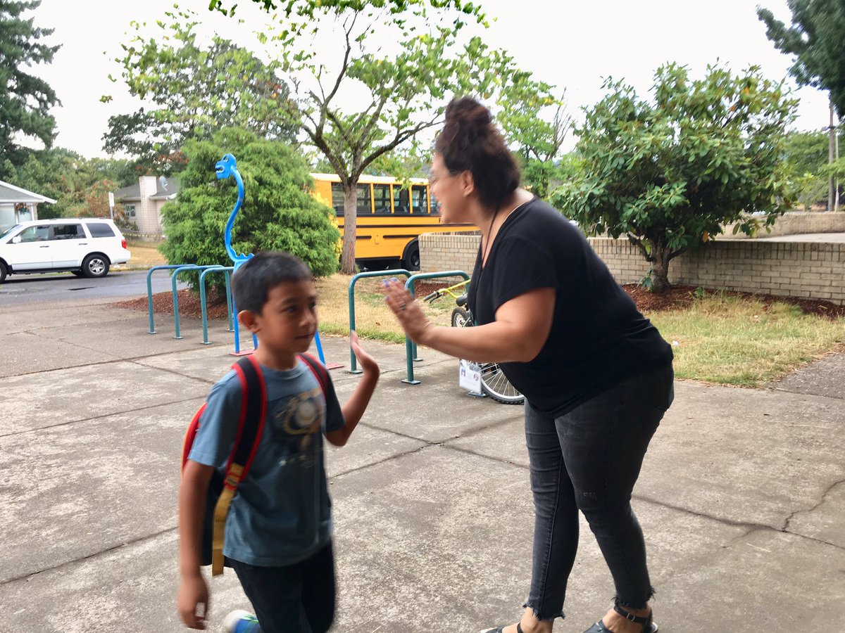 PPSConnect's tweet photo. Latinx leaders welcoming students to K-8 School. A few morning sprinkles didn’t dampen spirits! #1DistrictPPS https://t.co/mmdzSZM9Ep