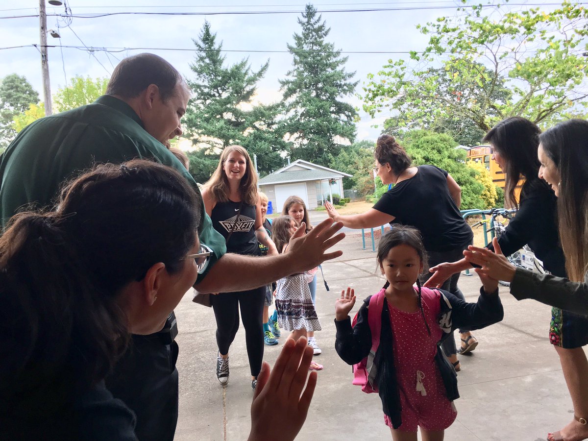 PPSConnect's tweet photo. Latinx leaders welcoming students to K-8 School. A few morning sprinkles didn’t dampen spirits! #1DistrictPPS https://t.co/mmdzSZM9Ep