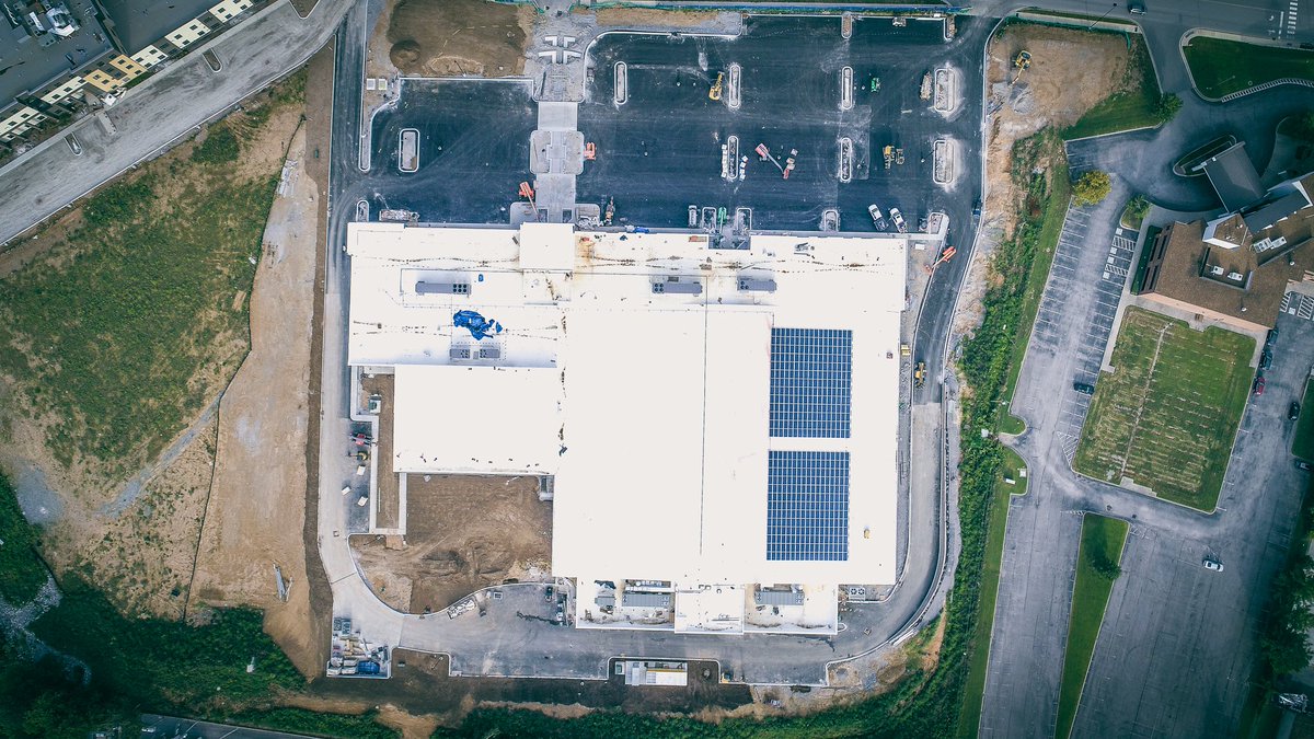 AmericanConst's tweet photo. 👉 Exterior: Binder (paving) &amp; curbs are completed, topsoil/landscaping are ongoing &amp; we’re detailing exterior skin of building. Interior: Even more activity - we have power/air so progressing on finishes like paint, flooring, etc. Won't be long! #bellevuetn #fordicecenter #preds https://t.co/audoYLNhZN