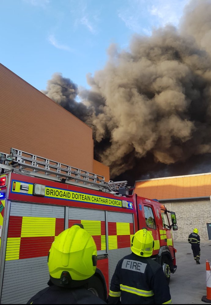 CorkCityFire's tweet photo. UPDATE: Large Fire in Douglas Shopping Centre, several units from around the city in attendance. 

Crews working very hard in heavy smoke and fire conditions to contain fire 🔥 🚒

⚠️ Please avoid the area to allow crews to access the building ⚠️
#corkfire https://t.co/F9P9Bk3zRc