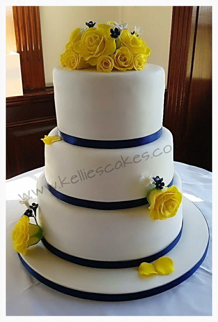 Three delicious flavours of vanilla,  lemon and red velvet for Joyce and Vincent's wedding cake,  topped with handmade sugar roses and blossoms and finished with navy ribbon. #weddings #sugarroses #flowerpro #yellowandnavy #gantshill #cakemaker