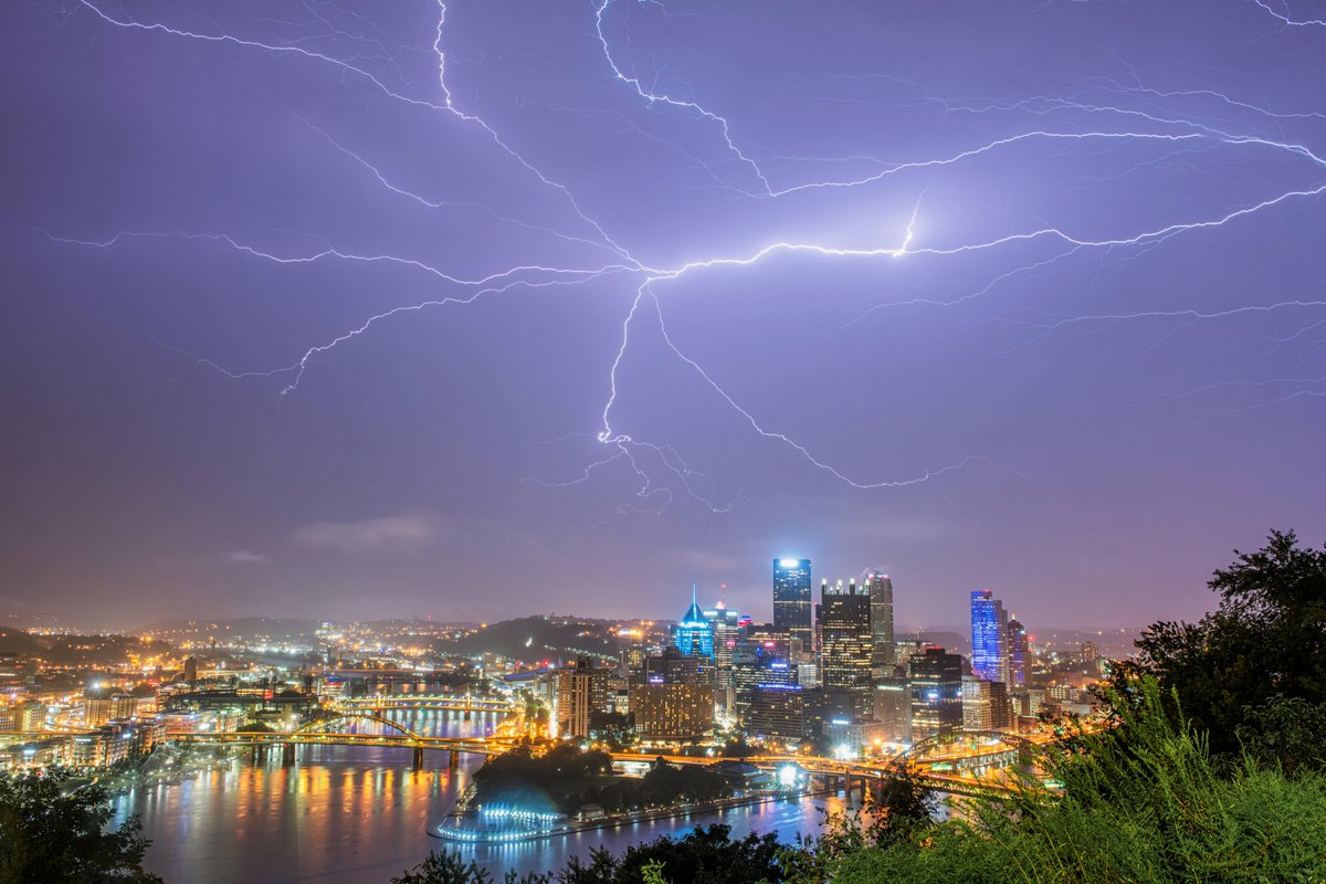 DaveDiCello's tweet photo. Last night's storms over #Pittsburgh were pretty incredible. In this image, a massive lightning bolt stretches nearly across the entire city, lighting up the sky and falling rain in the middle of the night. So cool to see all the little branches coming off the main bolt. https://t.co/xl3zJ4OQgY