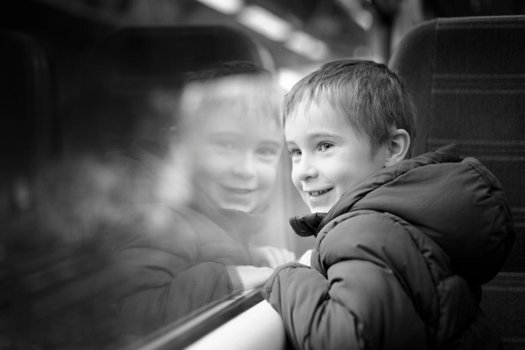 boy smiling looking out window
