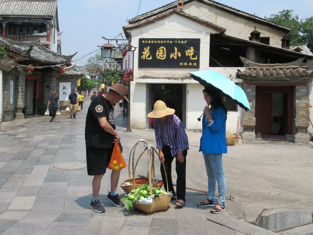 TravelStanley's tweet image. An ambulant vendor makes a sale on #Hanlin Street in the old city of #Jianshui, #Yunnan, #China.