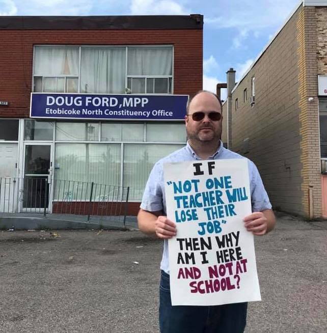 Unemployed teacher in front of Doug Ford office 