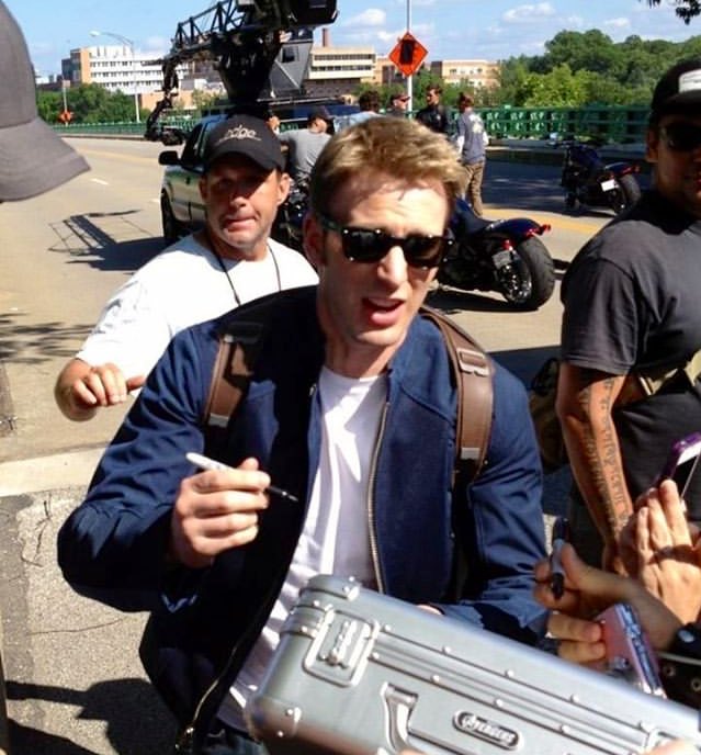 nomadmjolnir's tweet photo. chris signing autographs with the shield on his back🥺 https://t.co/mHrlyTtK2I