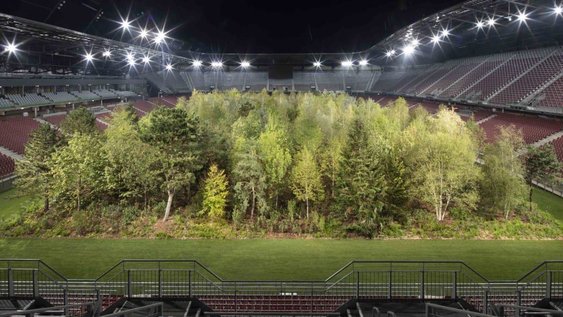 MLSist's tweet image. Breathtaking: Swiss curator Klaus Littmann installed an entire forest, basically, into the home stadium of Austrian side Austria Klagenfurt, who agreed to play elsewhere until the piece is removed in late October. His work was inspired by a 70's illustration, pictured below.