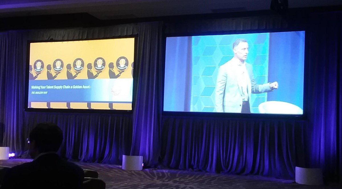 VDartInc's tweet photo. VDart and Bruce Hay attended the @SIAGigE Conference. Learned a lot from @johnerossman keynote speaker, former @Amazon executive.

'Make Your #SupplyChain a Golden Asset' - Keynote

#innovation #digitalstrategy #IoT #ThinkLikeAmazon #TheAmazonWay @SIAnalysts https://t.co/WBeUWbOTLY